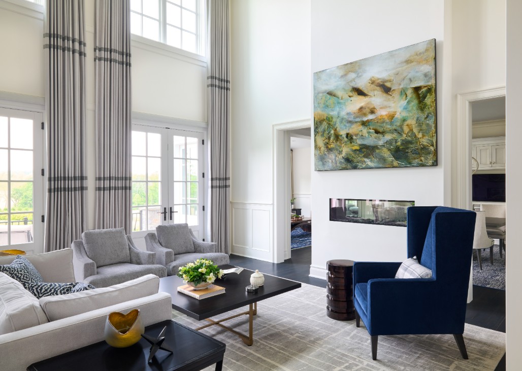 Elegant great room design featuring floor-to-ceiling drapes, modern artwork, and custom furnishings reflecting a personal design fingerprint.