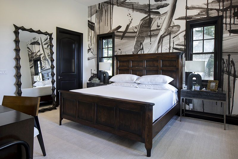 Modern bedroom with sculptural wall mirror and bold black-and-white wallpaper showcasing luxury interior design contrast