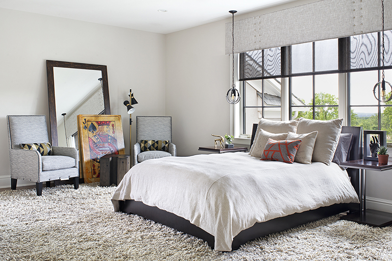 Guest bedroom interior design with floor mirror reflecting light and layered artwork for a spacious, curated feel