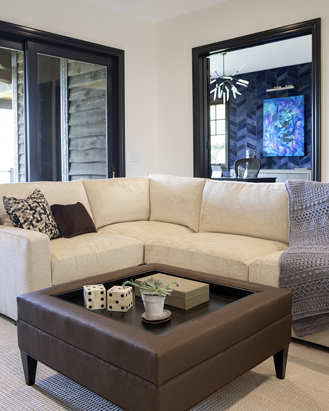 Cozy kid-friendly media room with cream sectional sofa, brown ottoman, and durable fabrics designed for family living.