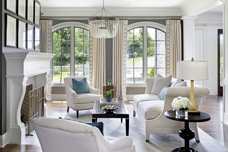 Bright living room with arched windows, light furniture, and dark accents demonstrating high contrast in interior design.