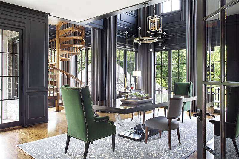 Sophisticated home office with dark paneled walls, spiral staircase, and green velvet chairs crafted for a bespoke interior.