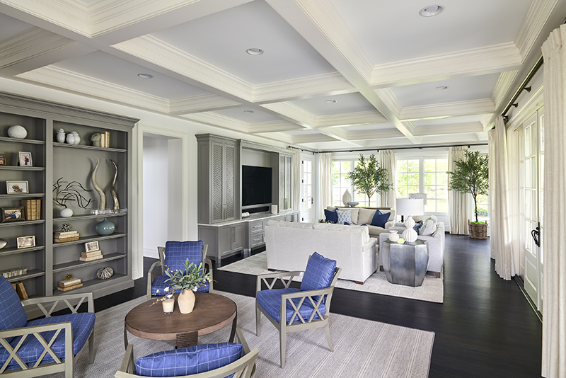 Neutral color palette interior design with layered textures, blue seating, soft area rugs, and light filled views that create a calming environment
